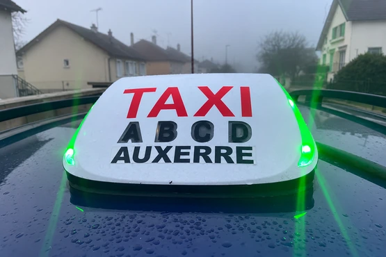 Un lumineux blanc porte les mots Taxi et Auxerre, avec les repères A B C D