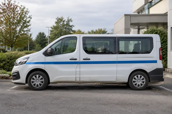 Fourgon sanitaire blanc vu de profil sur une aire de stationnement